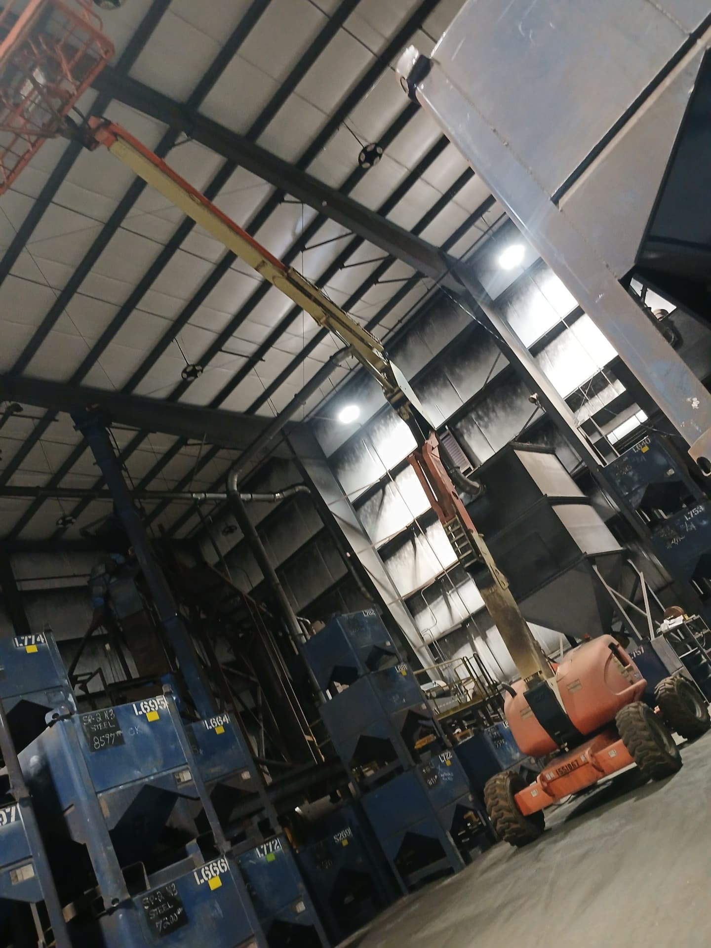 Industrial plant interior with boom lift during electrical work