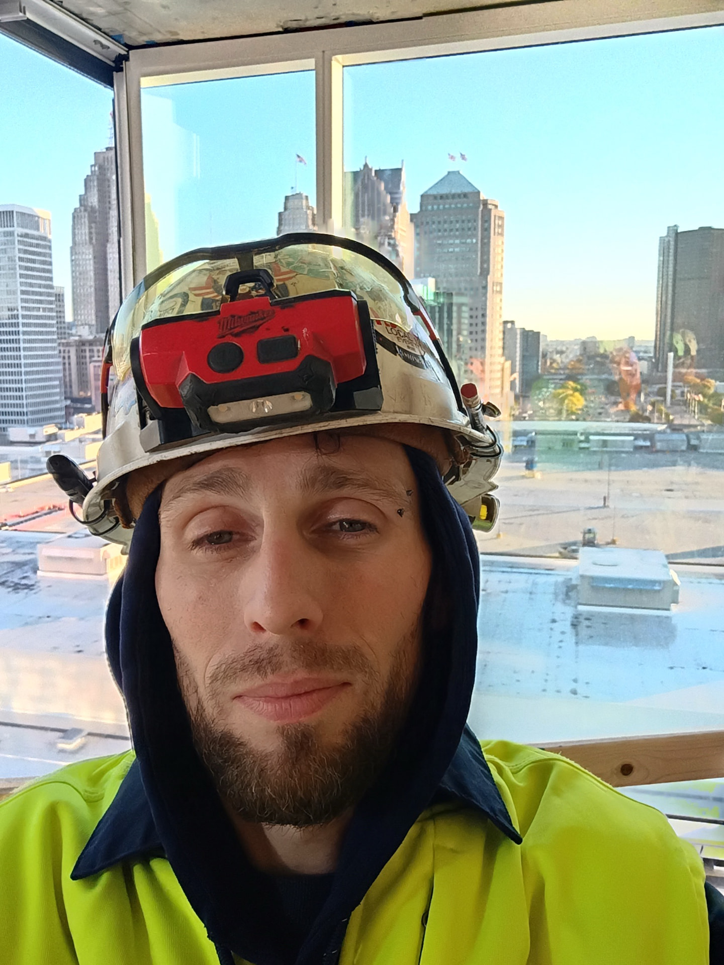 Electrician inside the Marriott building with the downtown Detroit skyline visible through the windows