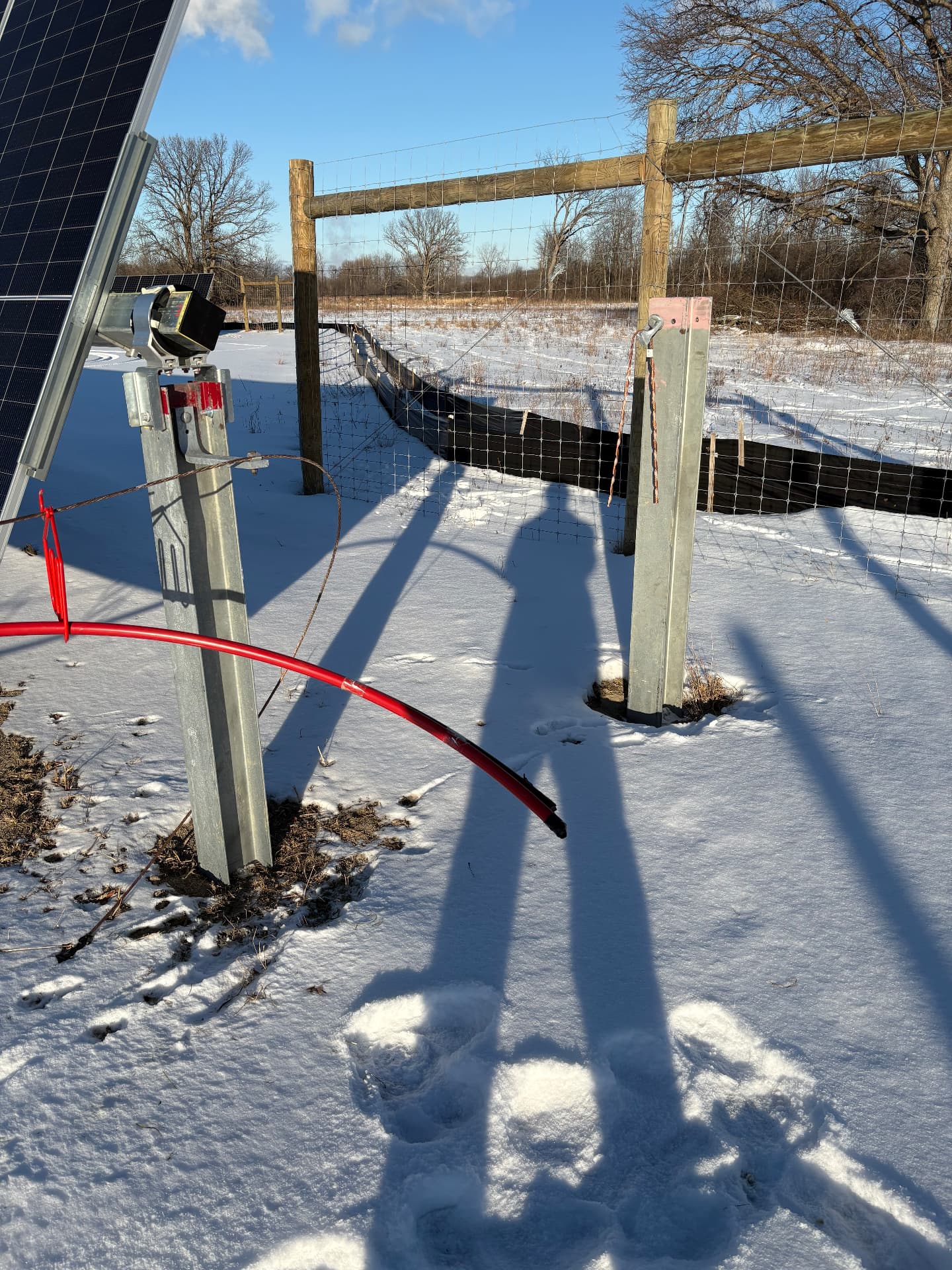 Solar tracker row foundation work at a solar farm in winter