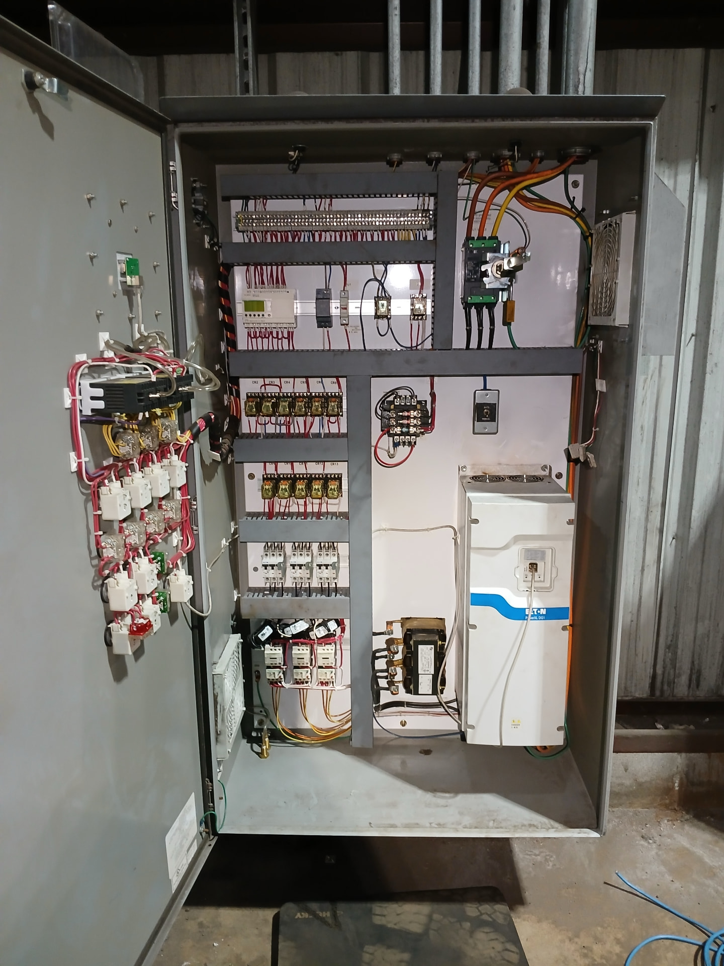 Open control panel with an Eaton PowerXL variable frequency drive and relay wiring