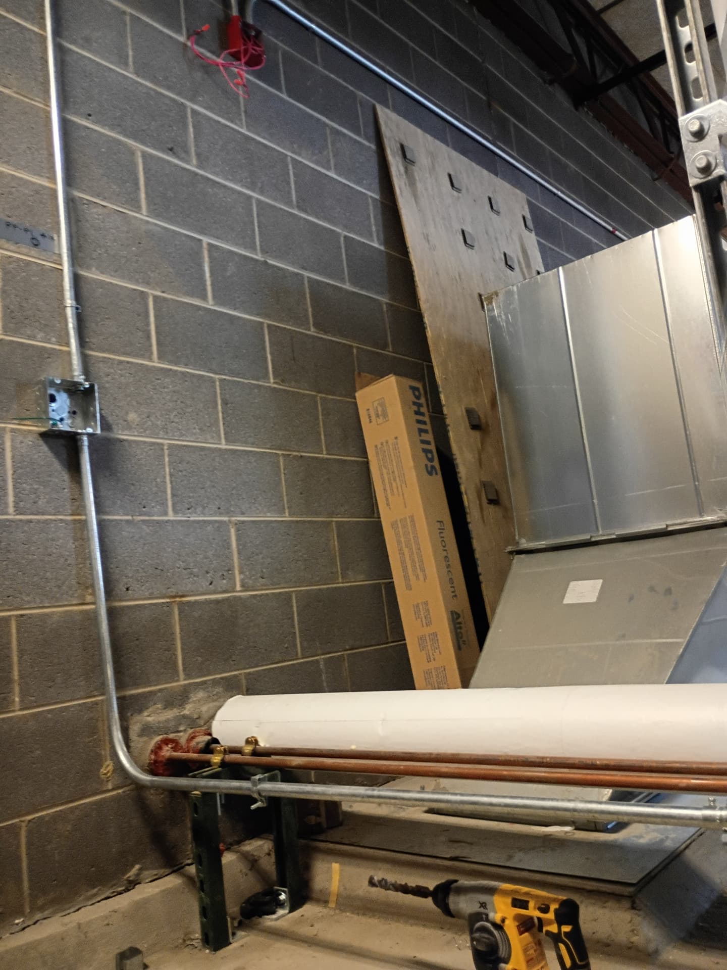 Electrical conduit and junction boxes installed in a mechanical room at a Novi school